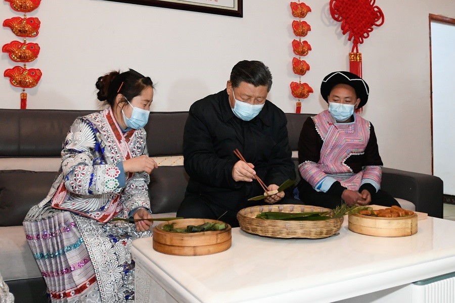 2021年2月3日下午，習(xí)近平在貴州畢節(jié)市黔西縣新仁苗族鄉(xiāng)化屋村苗族村民趙玉學(xué)家，同一家人邊聊家常邊制作當(dāng)?shù)貍鹘y(tǒng)節(jié)日食品黃粑。新華社記者 李學(xué)仁 攝