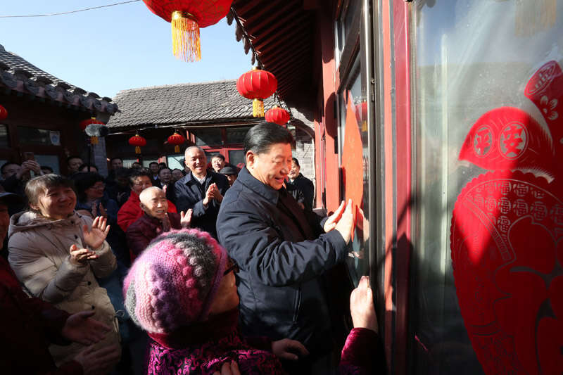 2019年2月1日上午，習(xí)近平在北京前門(mén)東區(qū)草廠四條胡同32號(hào)院，高興地拿起一幅“?！弊?，親自貼到門(mén)上，給這里的老街坊們拜年。新華社記者 鞠鵬 攝