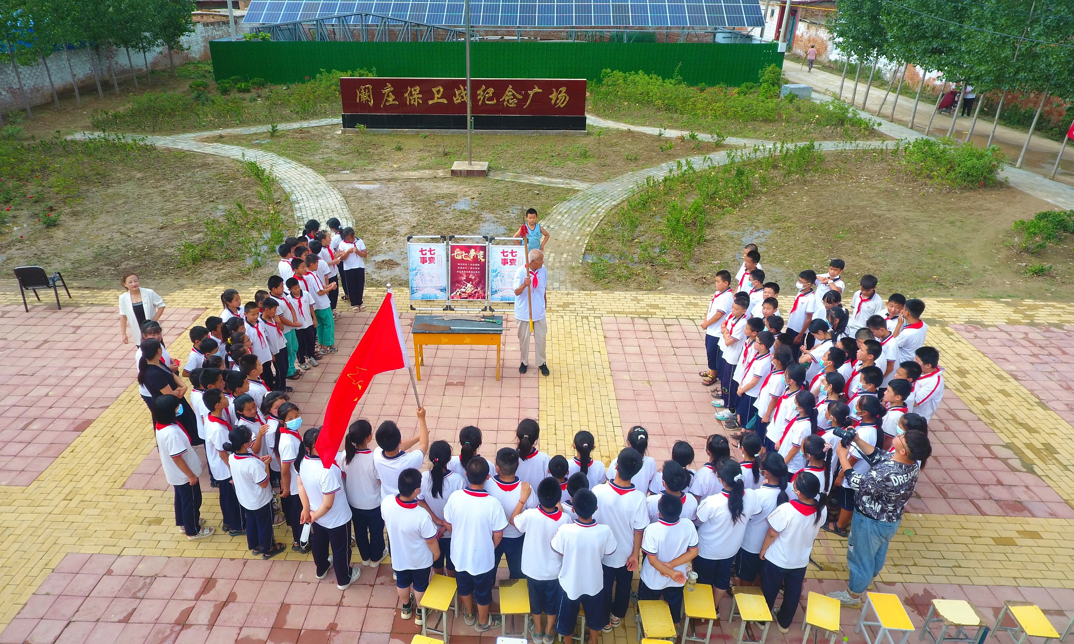 2022年7月6日，山東省聊城市，在茌平區(qū)菜屯鎮(zhèn)闞莊村的闞莊保衛(wèi)戰(zhàn)紀(jì)念廣場(chǎng)，闞莊保衛(wèi)戰(zhàn)親歷者王光木老人，為小學(xué)生們講述抗戰(zhàn)故事，展示大刀、長(zhǎng)矛。